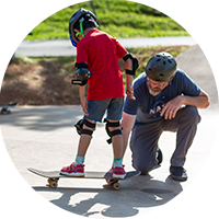 Adult Instructing a Child on Skateboarding